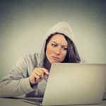 Eine Frau sitzt aggressiv vor einem Laptop und versucht ein Problem mit der KO zu lösen.