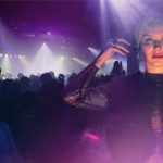 DJ mit Kopfhörern vor Bühnenlicht und Publikum bei Musikveranstaltung München Beats