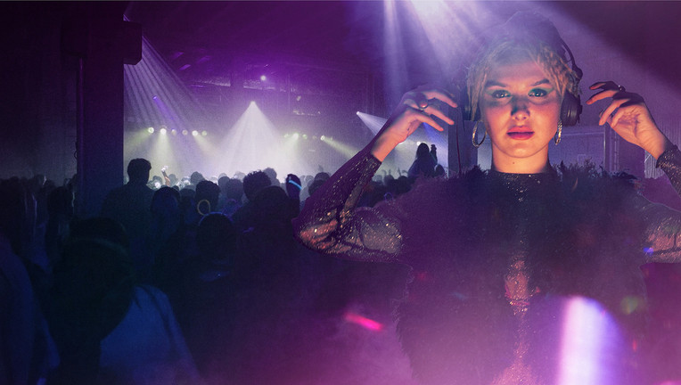DJ mit Kopfhörern vor Bühnenlicht und Publikum bei Musikveranstaltung München Beats